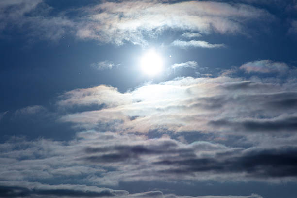 The sky is cloudy, and the sun is shining brightly. The clouds are white, and the sun is yellow.