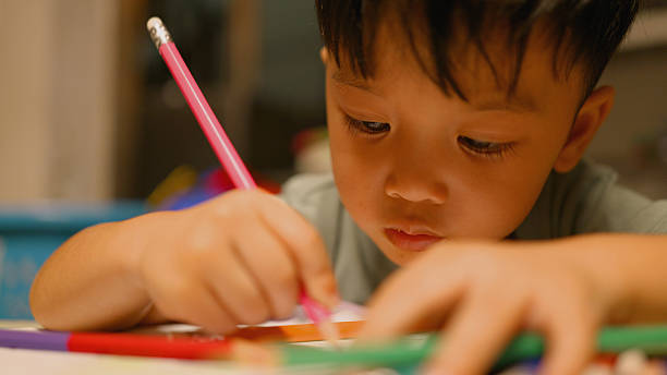 istock Asian Kindergarten Boy Coloring Homework After School – Creative Learning Concept. 2219591401
