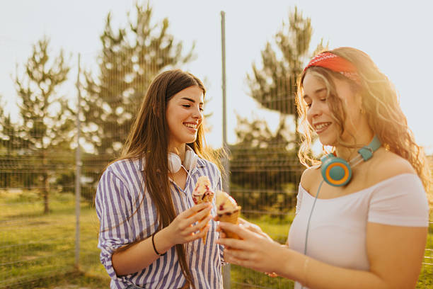 istock Two young female friends refreshing with ice-cream while spending sunny day in nature 2219591822