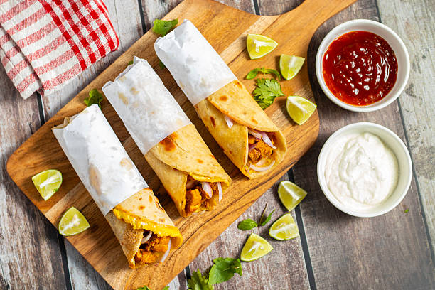 istock Egg chicken roll is a popular street food made with a flaky paratha, spiced chicken, egg layer, onions, and sauces, wrapped and served hot. 2219591843