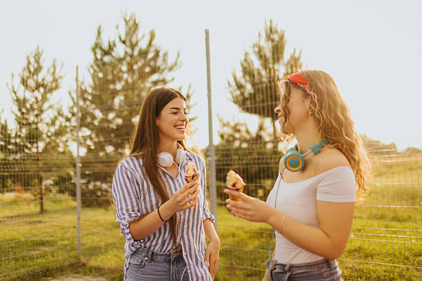 istock Two young female friends refreshing with ice-cream while spending sunny day in nature 2219592754