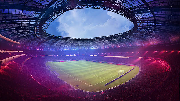 istock 3D render. Hand made collage. Large stadium with open circular roof and clear blue sky above vibrant football field surrounded by fans. 2219592995