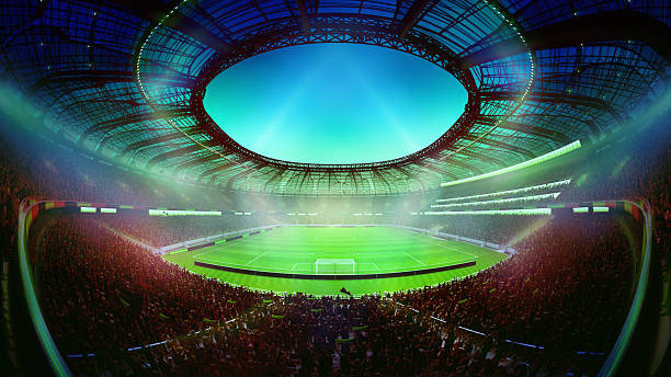 istock 3D render. Hand made collage. Wide angle view of soccer arena with green flashlight effect illuminates full stadium with packed crowd and glowing sky 2219593000