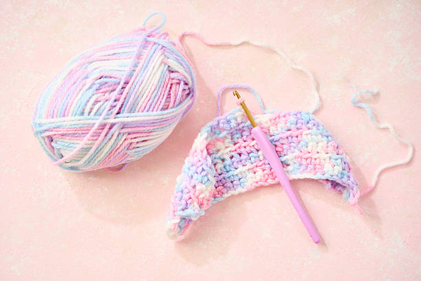 istock Cute crochet project with pastel yarn and hook on pink background 2219598587