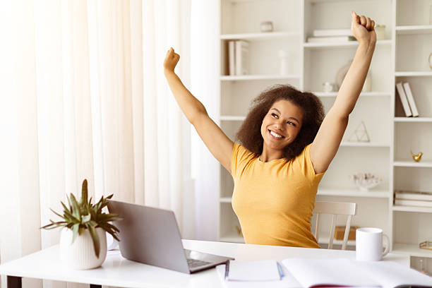 istock Smiling young black female freelancer stretching after working day at home office 2219601837