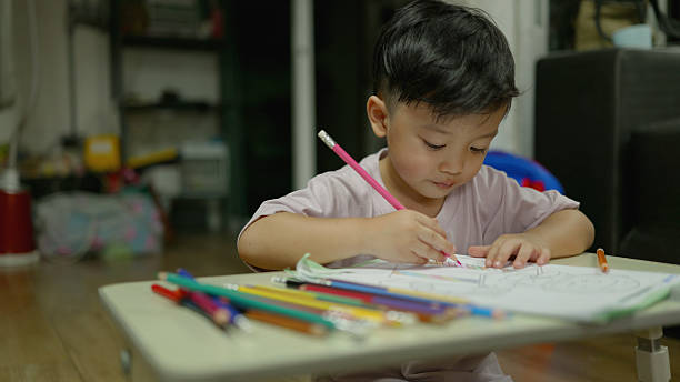istock Asian Kindergarten Boy Coloring Homework After School – Creative Learning Concept. 4k 2219602163