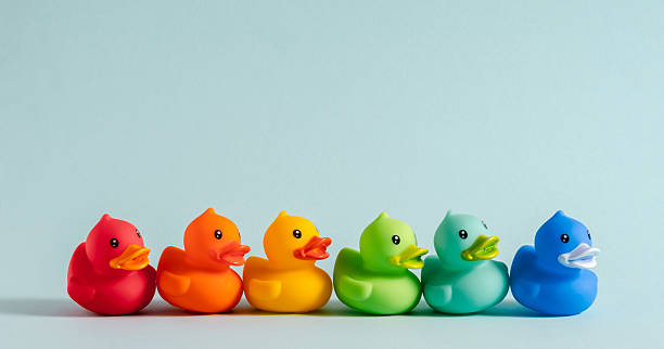 istock Colorful rubber ducks arranged in a rainbow row on a pastel blue background. Fun and playful minimal composition with bright colors and cheerful mood. 2219602252