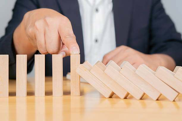 istock Safety business development concept. Businessman hand stopping falling blocks on table 2219606715