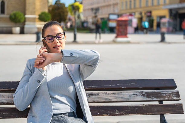 istock Elegant businesswoman sitting on bench during phone call, expressing different emotions happiness, anger, calmness, multitasking in outdoor urban setting on a work break. Office worker outdoor. 2219610421