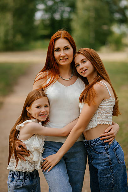 istock Mother and Daughters Embracing Outdoors in Nature 2219610805