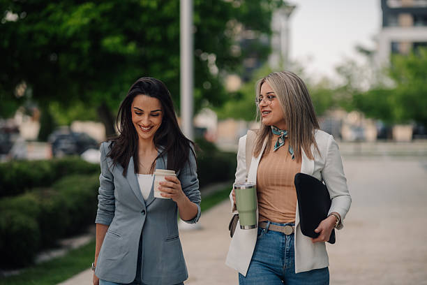 istock Two businesswomen walking and talking during coffee break 2219610989