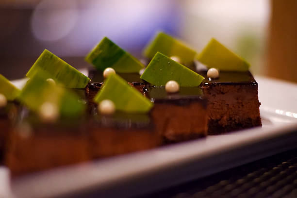 Small square cakes arranged in a beautiful plate for a party.