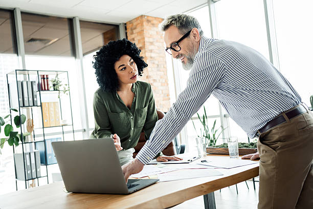 istock Business professionals collaborating on project in a modern open office space with natural lighting and elegant decor 2219613392
