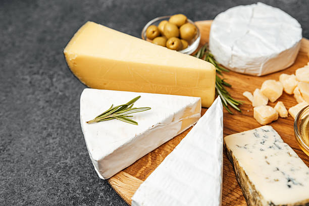istock Cheese platter with various types and garnishes on wooden board 2219615873