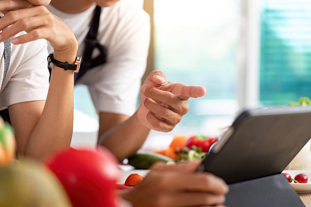 istock Couple Learning Together. Engaging with a tablet while preparing a healthy meal. 2219618202