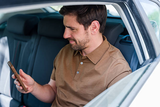 istock Businessman using smartphone while sitting in backseat of car 2219620995