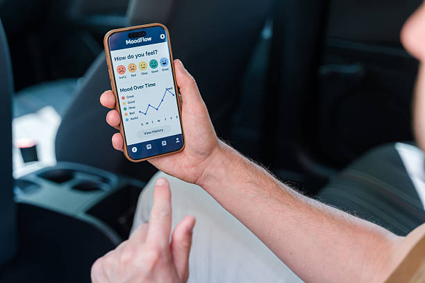 istock Man using mood tracking app on smartphone in car 2219621229