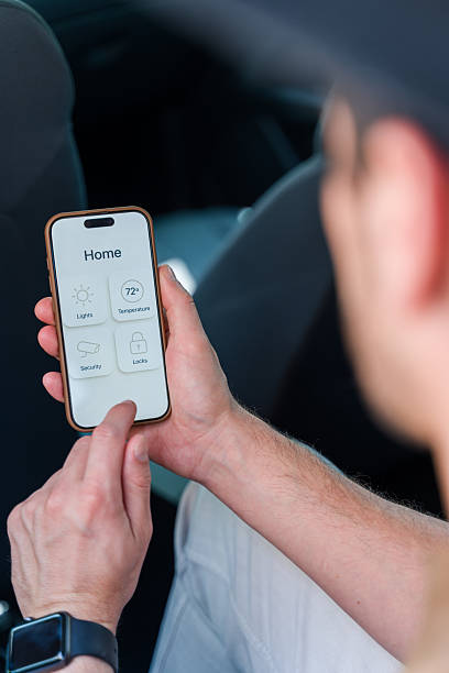 istock Man controlling home automation from his car using smartphone app 2219621235