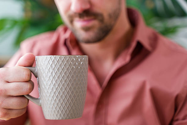 istock Man holding a mug in front of him 2219621415