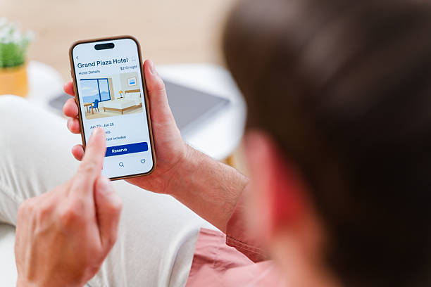 istock Man reserving hotel room online using smartphone app 2219621649
