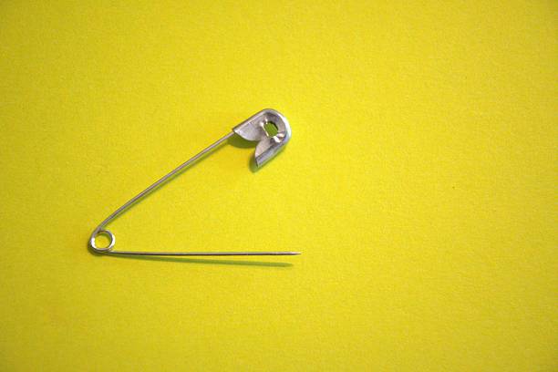 Metal safety pin with yellow background.