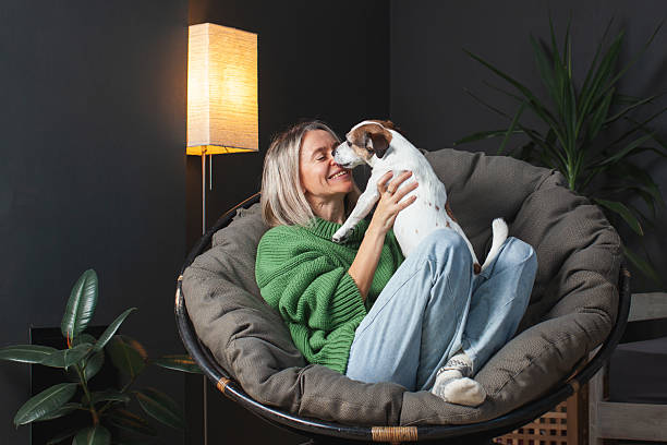 istock Middle age Woman with her Dog resting on sofa at Home 2219625148