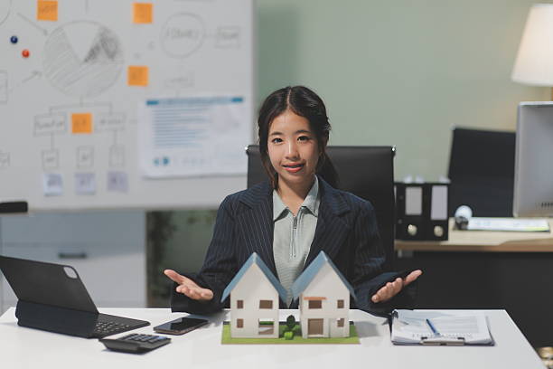 istock Real estate agents explain models of housing estates in projects to elaborate to clients, explaining and presenting information about homes and purchasing loans. Real estate trading concept. 2219625621