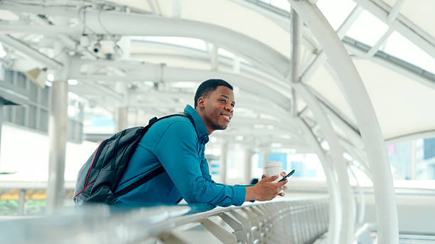 istock Young African professional leaning on railing with smartphone in modern city 2219625963