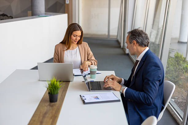 istock Business people working together at office desk using laptops and documents 2219628377