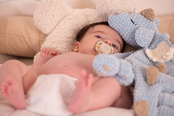 A baby hat, toys, pacifier on a white background. Preparing for motherhood. Shopping for baby.