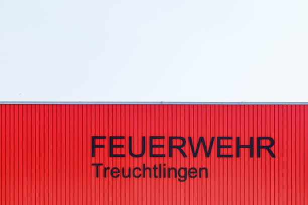 The image shows a red building facade with vertical ribbing. The words \