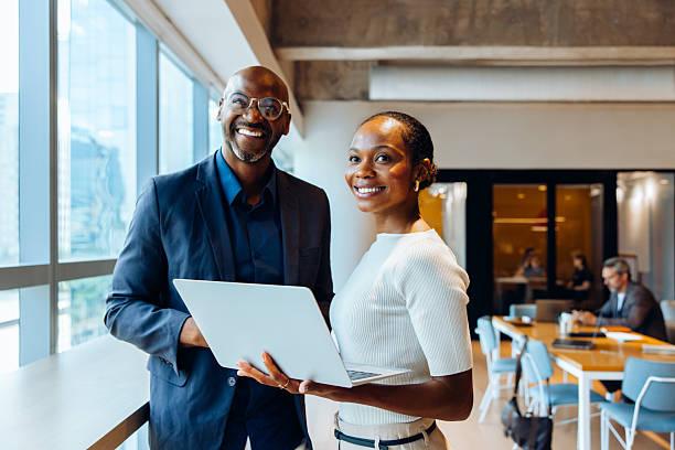 istock Smiling coworkers with a laptop in a bright, professional office setting 2219635135