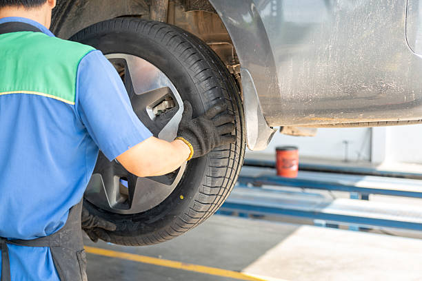 istock Installing a car wheel after new tire replacement. 2219635409