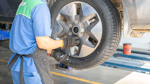 istock Installing a car wheel after new tire replacement. 2219635472