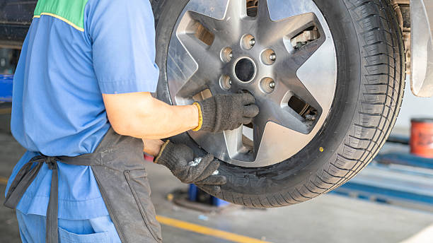 istock Installing a car wheel after new tire replacement. 2219635555