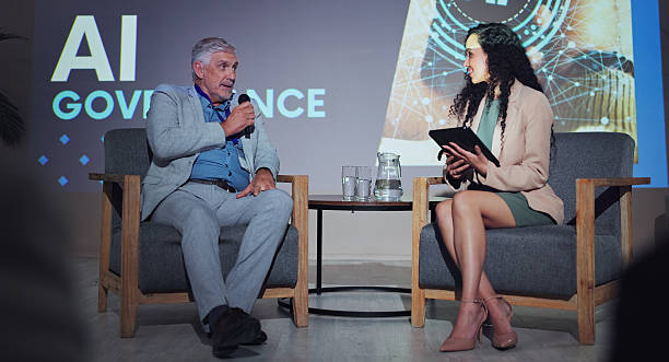 istock Seminar, interview and people at screen for presentation, AI governance and risk management for ethical usage. Government official, woman and tablet on stage for feedback, policy guidelines and FAQ 2219635666