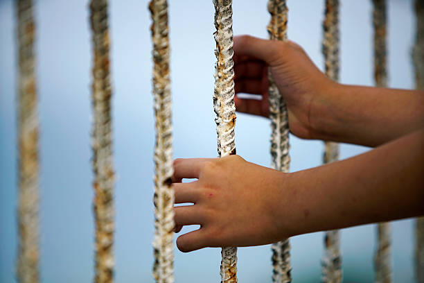 istock Hands Reaching Through Weathered Ropes by Calm Blue Water 2219635738
