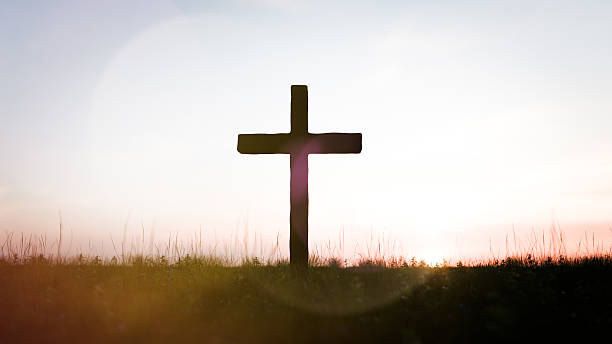 istock Silhouette of a cross against a sunset sky 2219638408