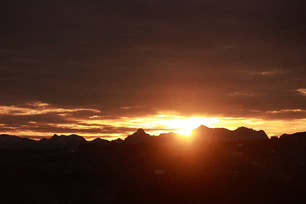 istock The sun is setting over a mountain range, casting a warm glow over the landscape 2219642320