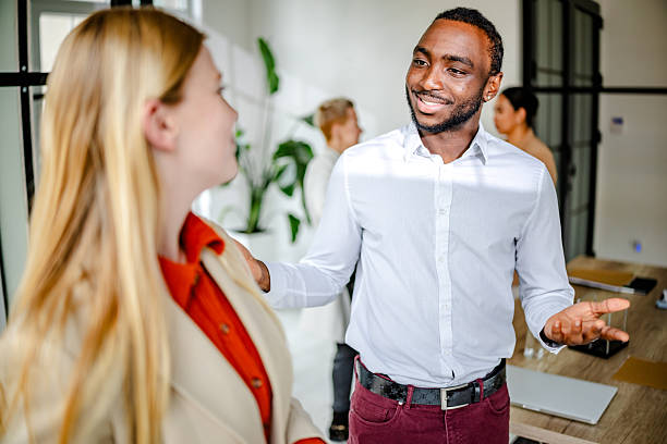 istock Young black man leads an engaging conversation with colleagues in a modern office setting 2219642921