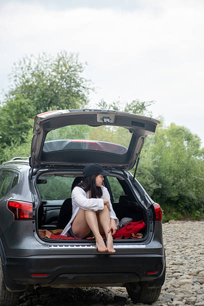 istock Woman Relaxing in SUV Trunk on Rocky Path 2219643304