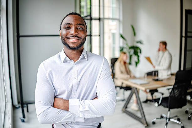 istock Young black man confidently leads his team in a modern office space during a strategic business meeting 2219643503