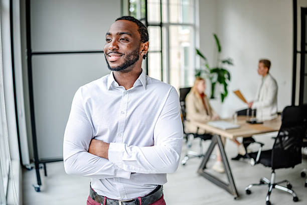 istock Young black man confidently leads in a modern office environment showcasing professionalism and leadership skills 2219643571