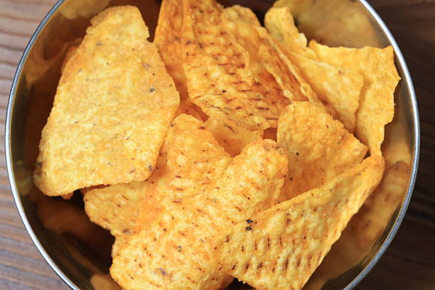 Close-up of triangle corn chips and tomato sauce in slow motion