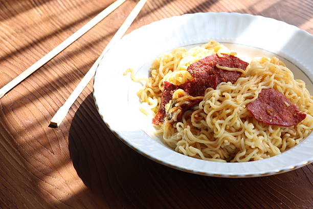 A bowl filled with food, accompanied by chopsticks. The food is a delectable mixture of fruits, vegetables, and other ingredients, suitable for a delicious dish