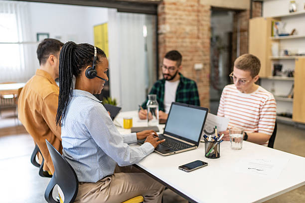 istock Customer service representative assisting clients online in a busy office 2219646170