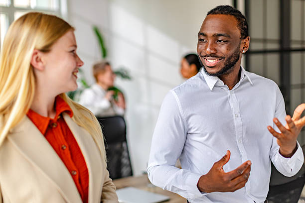 istock Young black man engages in lively conversation with colleague in a modern office setting 2219646217