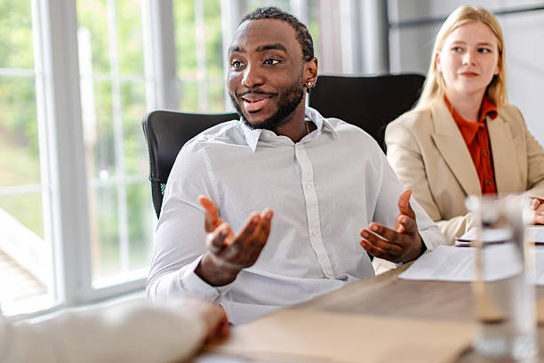 istock Young black man leads a dynamic discussion in a modern office environment 2219647471