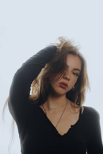 istock Young woman playing with her hair on white background 2219648565