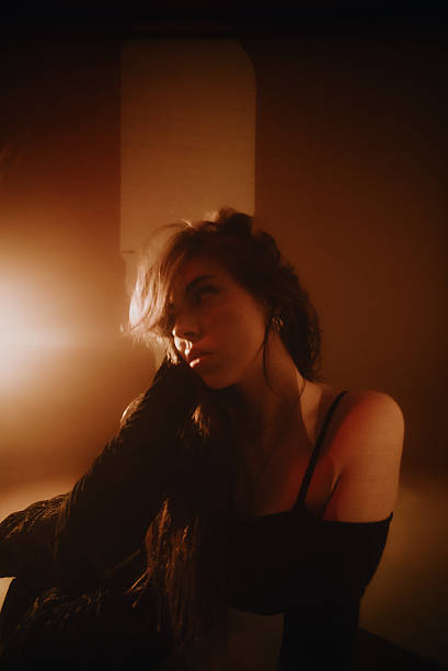 istock Young woman posing in warm light looking at camera 2219648897